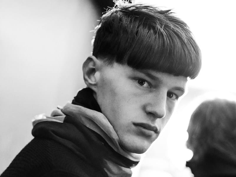 An astonished guy with a bowl-cut hairstyle