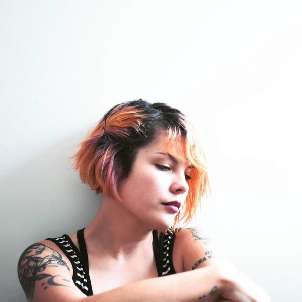 short wavy hairstyle with bright orange highlights
