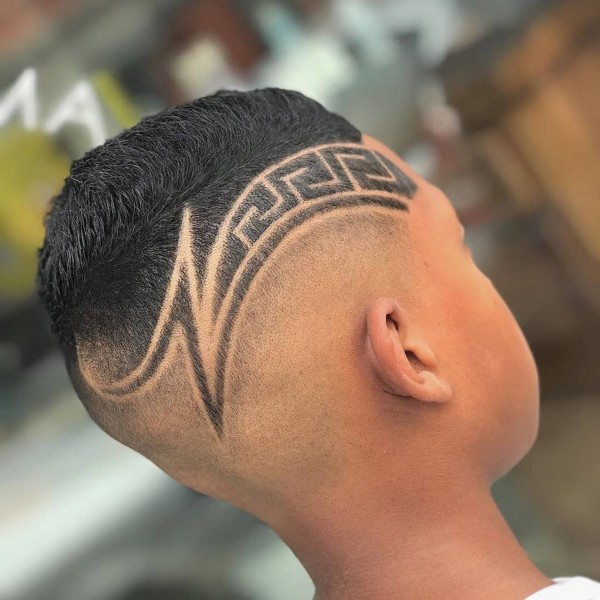 A faded haircut with an original design for boys.