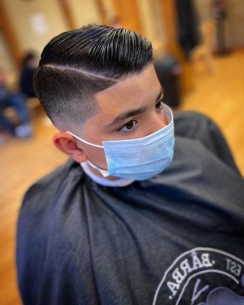 Young boy with a Temp Fade with Part Side haircut and a protected mask.
