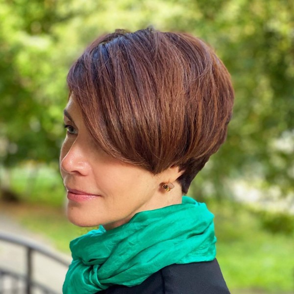 A long pixie haircut with side-swept bangs for ladies.