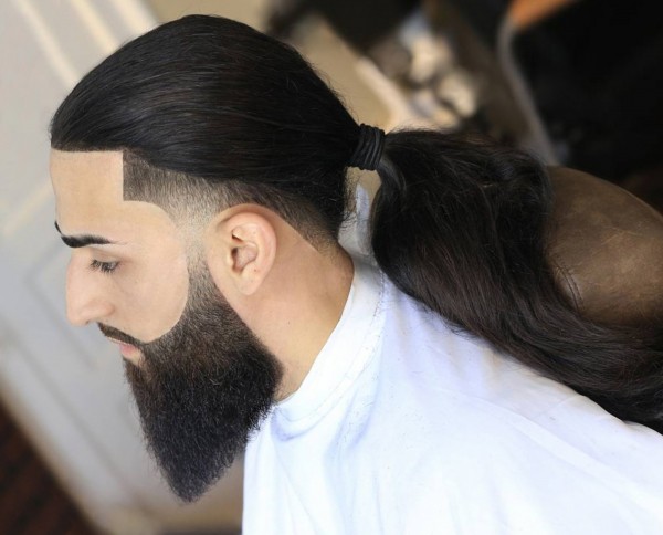 A full beard combined with a tapered fade cut.
