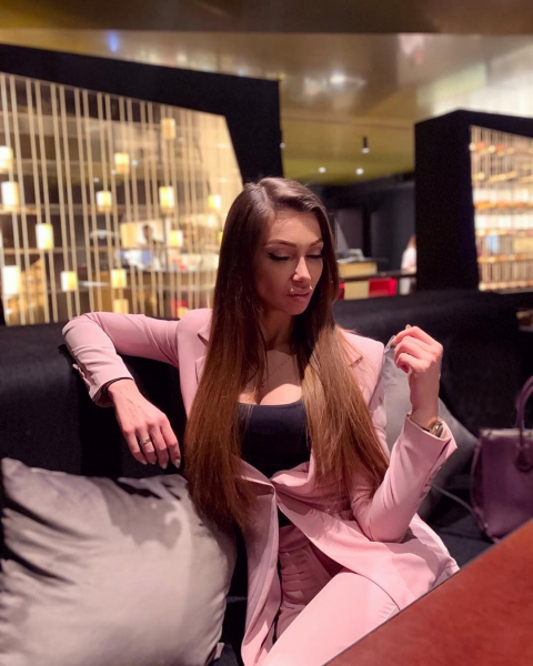 Julia with a pink business suit and long straight hair