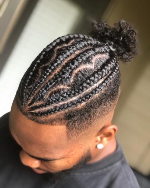A male bun hairstyle with cornrows.
