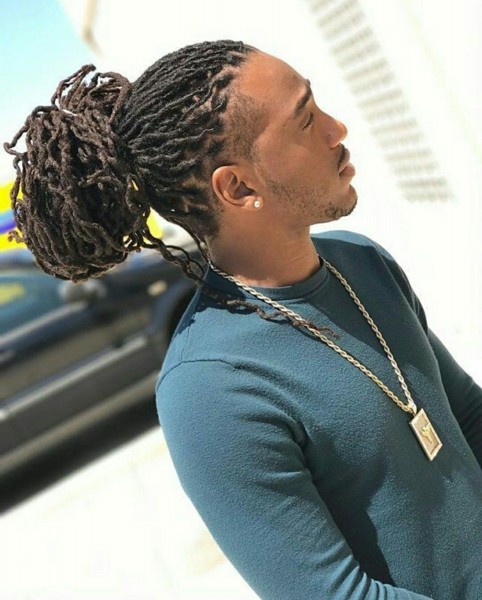 A faux locs male hairstyle with a bun.