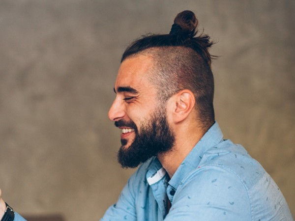 A high faded male hairstyle with a bun.
