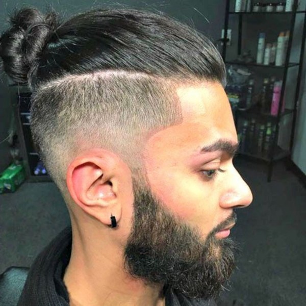 A male mid-faded haircut with a bun.