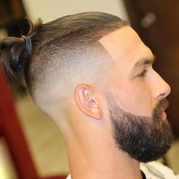 A man bun with the shaved sides hairstyle.