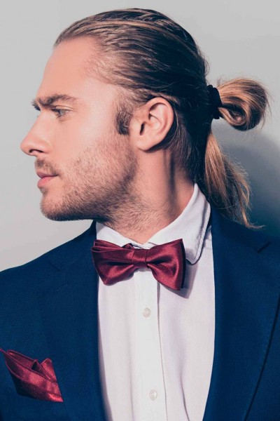 A male bun hairstyle for a wedding party.